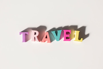 Travel Word made of colorful wooden letters on a White Background