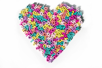 Plenty of colorful wooden letters on a White background shaped in a Heart Form