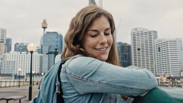 Alluring brunette smiles at the camera with the Sydney Tower and city skyline in the background