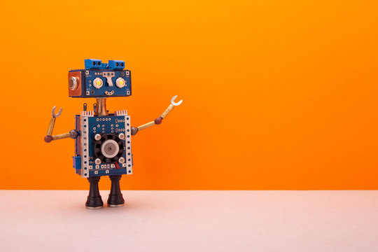 A smiling robot with a blue head and torso looks away from itself. A steampunk toy on a background of an orange wall and a light beige floor. Free space for text and design.