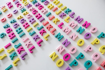 Plenty of colorful wooden letters on a White background