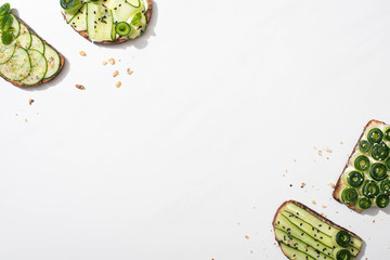 top view of fresh cucumber toasts on white background