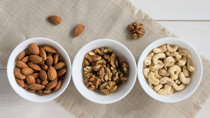 diet food concept, almonds, walnuts and cashew nuts on a wooden table
