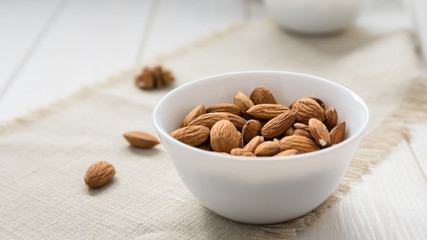 diet food concept, almonds in a white plate on a wooden table