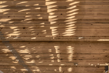 Close-up view of wooden beams, rafters, joist with nail plates on the roof of a commercial real...
