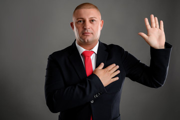 Businessman dressed in suit shows oath