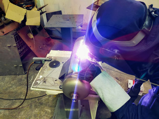 Metal workers use manual labor. Skilled welder. Factory workers making OT. Welder is welding the...