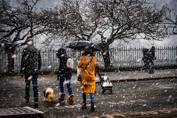 People walking in Princes Street during a snow in Edinburgh, UK.