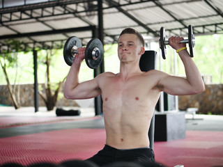 Fototapeta na wymiar Handsome man doing the exercise with dumbbells, lifestyle concept.