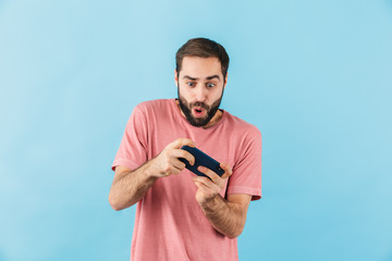 Nervous man isolated play games by mobile phone.