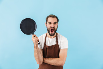 Screaming displeased man holding frying pan.