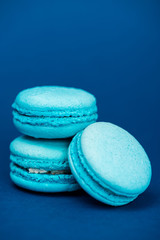 tasty french macaroons on blue background with copy space