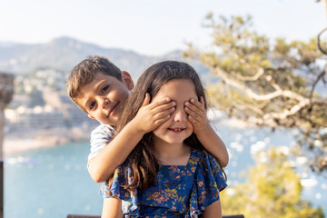 Fototapeta na wymiar Funny boy covering eyes to his little friend