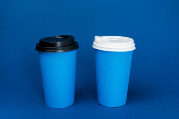 paper cups with coffee on classic blue background