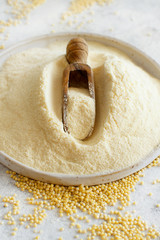 Hulled millet flour on a ceramic plate and grain