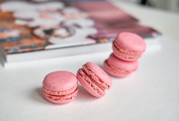 layout flat lay photobook and pink macaroons, focus on one object macro 