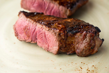 Steak. Grade A, grass fed angus beef. Traditional classic New York steakhouse menu favorite. T-bone steak, bone in, cooked to medium to rare and sliced. 
