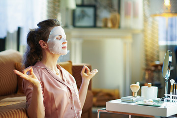 relaxed elegant woman with facial mask meditating