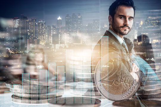 double exposure of attractive businessman and his colleagues at meeting with city night, money coins stack and growth statistic graph, business teamwork, investment and partnership concept.