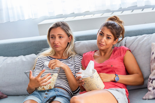 Two Best Friends Watch Sad Movie At Home In Bed Crying Touching. Girls Hold Popcorn And Tv Remote Control Looking Screen Romantic Film On Television. Ladies In Pajama Wiping Tear Using Tissue