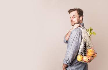 Man holding eco friendly (zero waste) shopping bag with food