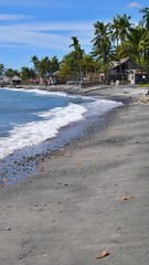 black volcanic sand at the beach of Dumaguette, Philippines
