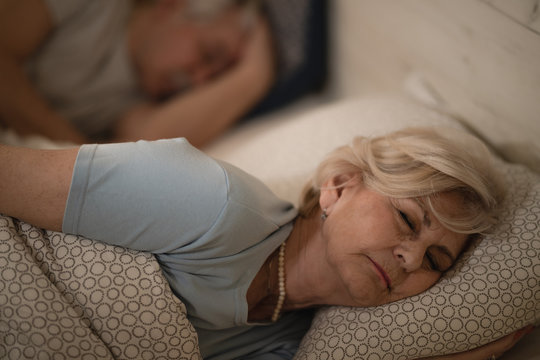 Tired Mature Woman Sleeping In Bed At Night.