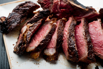 Steak. Grade A, grass fed angus beef. Traditional classic New York steakhouse menu favorite. T-bone steak, bone in, cooked to medium to rare and sliced. 