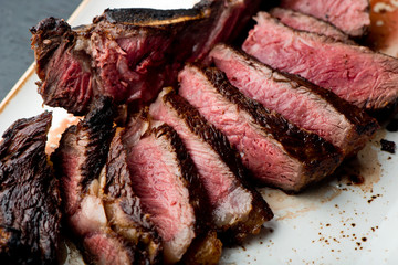 Steak. Grade A, grass fed angus beef. Traditional classic New York steakhouse menu favorite. T-bone steak, bone in, cooked to medium to rare and sliced. 