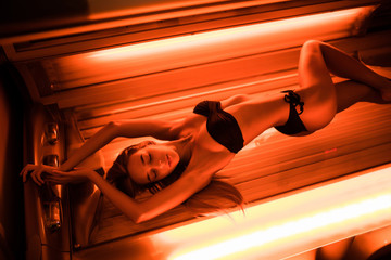 Beautiful young woman have tanning skin treatment in modern solarium - obrazy, fototapety, plakaty