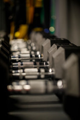 Close up many metal dumbbells on rack in sport fitness center. Weight Training Equipment concept. Sport and fitness, exercise design.