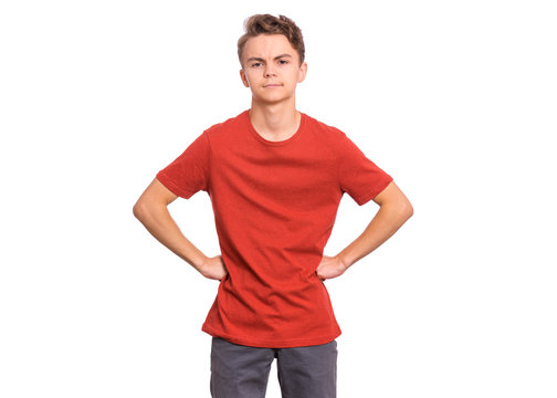Upset handsome caucasian Teen Boy with hands on waist, isolated on white background. Angery teenager looking at camera. Unhappy child portrait.