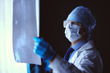 Young doctor looking X-Ray image on isolated white background