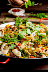 Paella. Traditional classic Spanish seafood dish with fresh seafood, shrimp, mussels, clams, squid cooked in fish broth with saffron and rice garnished with cilantro. 