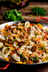 Paella. Traditional classic Spanish seafood dish with fresh seafood, shrimp, mussels, clams, squid cooked in fish broth with saffron and rice garnished with cilantro. 