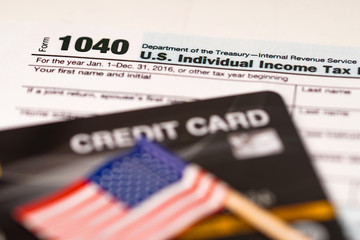 Tax Return form 1040 with credit card and USA flag : U.S. Individual Income.