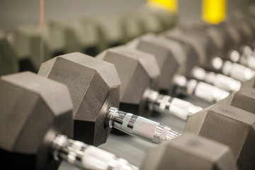 Naklejka premium Rows of black dumbbells in the workout gym in high resolution and urban style.