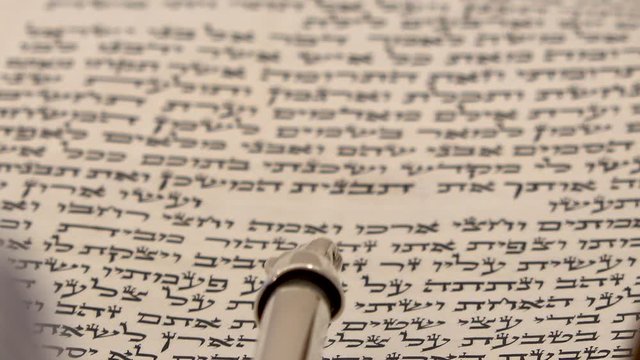 Torah bible reading text with pointer. Aramaic and Hebrew letters from holy book Zohar or Kabbalah. Close up shot on sacred spiritual texts