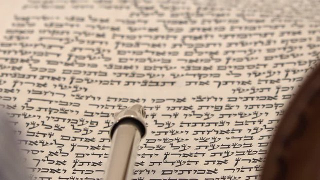 Close up shot on sacred spiritual texts and letter. Torah bible reading text with pointer. Aramaic and Hebrew letters from holy book Zohar or Kabbalah.