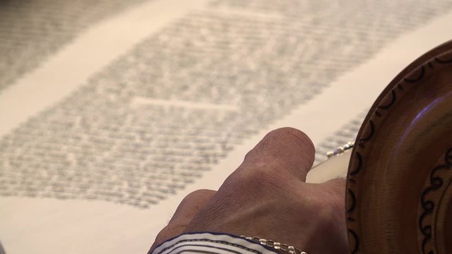 Torah bible reading text with pointer. Aramaic and Hebrew letters from holy book Zohar or Kabbalah. Close up shot on sacred spiritual texts