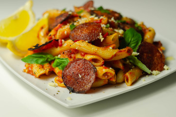 Pennette pasta in a spicy tomato sauce with sliced pepperoni, mozzarella, and mature cheddar cheeses