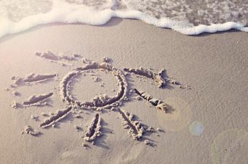 Sun drawing in the sand on happy holidays. Summer, travel and relax. Copy space.