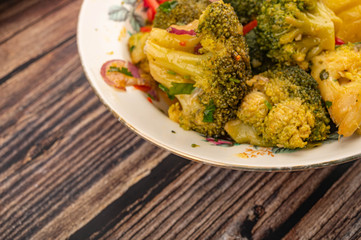 Vegetable salad in a white ceramic plate on a wooden background. Close up.