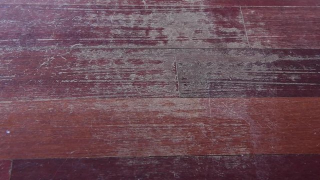 Old scratched hardwood flooring in need of maintenance. Parquet ruined by scratches made by prolonged use of chair needing repair. View from above with zoom in camera movement