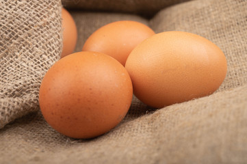 Chicken eggs on a background of rough homespun fabric. Homemade preparations, rustic treats. Close up.