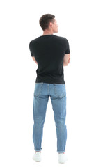 Fototapeta premium rear view. guy in a black t-shirt staring at a white wall
