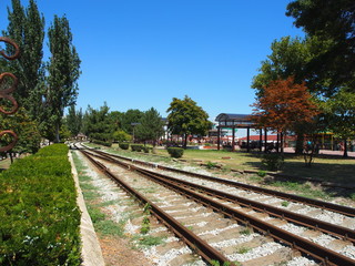 Obraz premium Railway tracks laid along the waterfront of the seaside town , summer day.