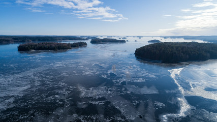 Aerial view of the winter lake and islands at sunny day. View from above captured with a drone in Finland.