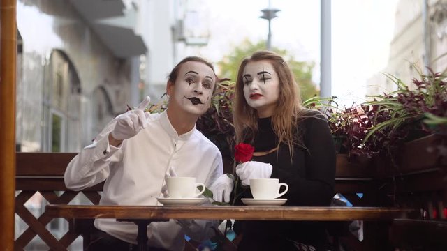 Two happy mime on a date in the cafe. Romantic date