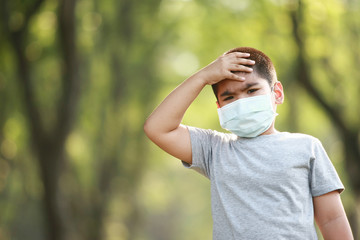 A young Asian boy , 7 Years Old , wear mask to protect against dust PM 2.5 and germs